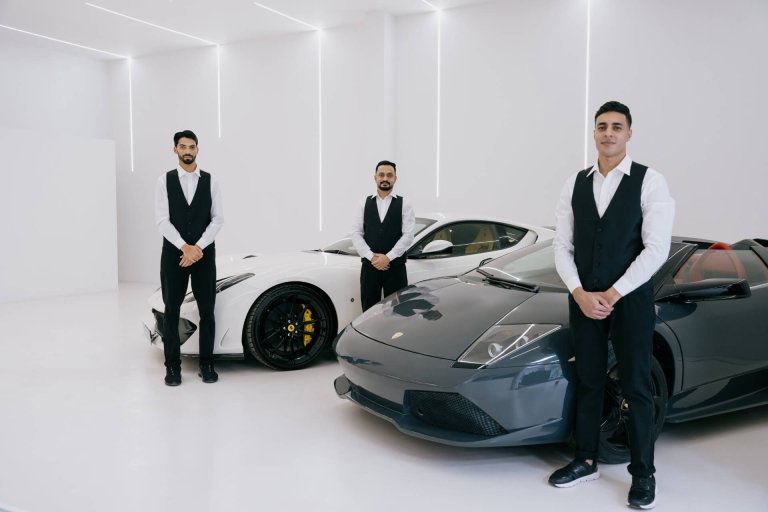 Luxe Valet Services parking attendants standing next to luxury cars
