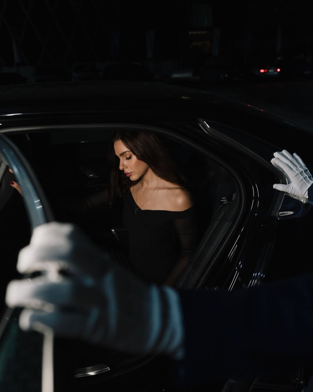 Valet parking attendant opening car door for woman